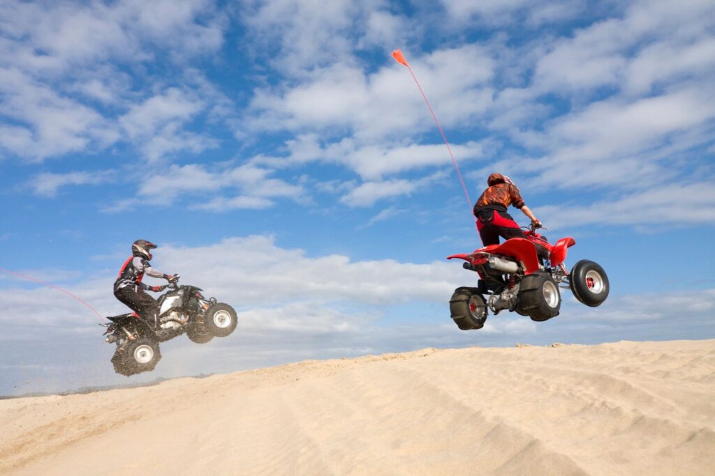 Two People jumping sand dunes on a desert